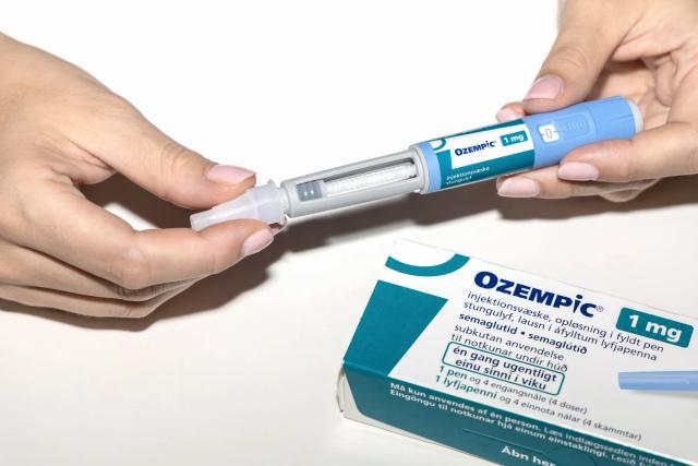 Patient holding Ozempic injection amid reports of severe gastrointestinal side effects