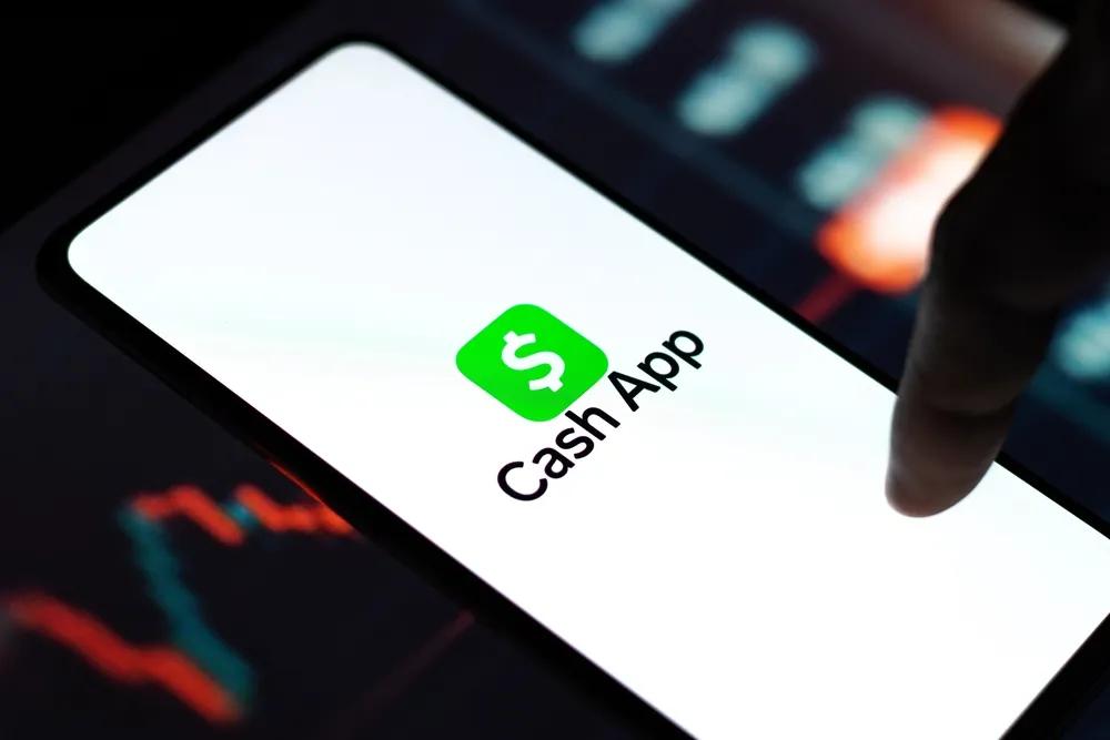 a finger on the Cash App icon