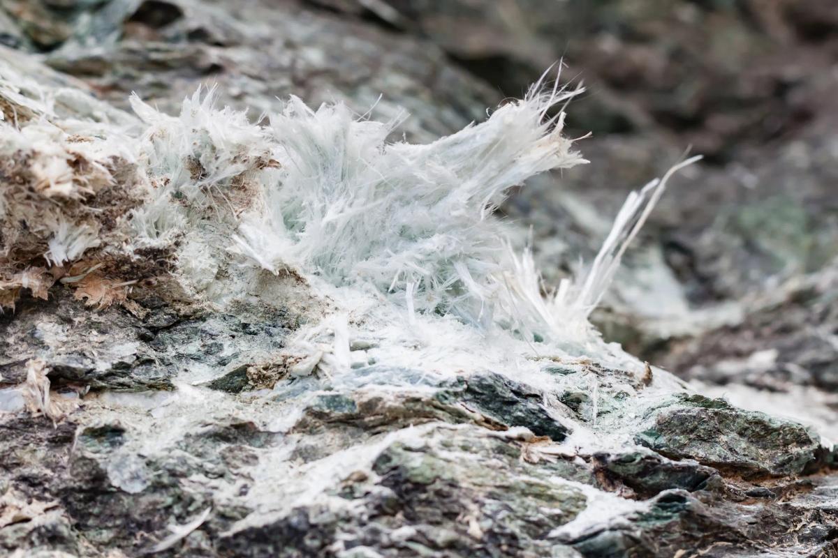 Raw asbestos mineral fibers on rock, linked to asbestos exposure lawsuits