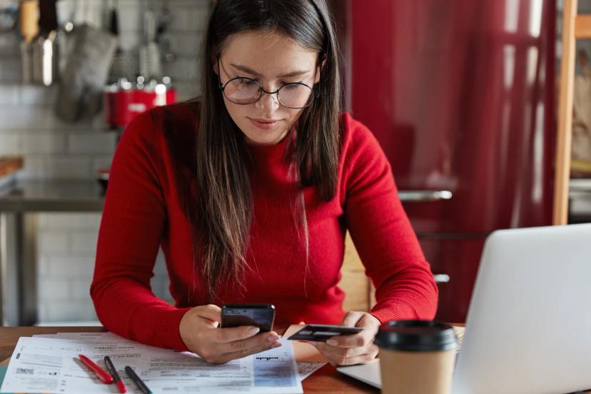 Business owner reviewing credit card settlement news on a mobile phone related to the Discover merchant case