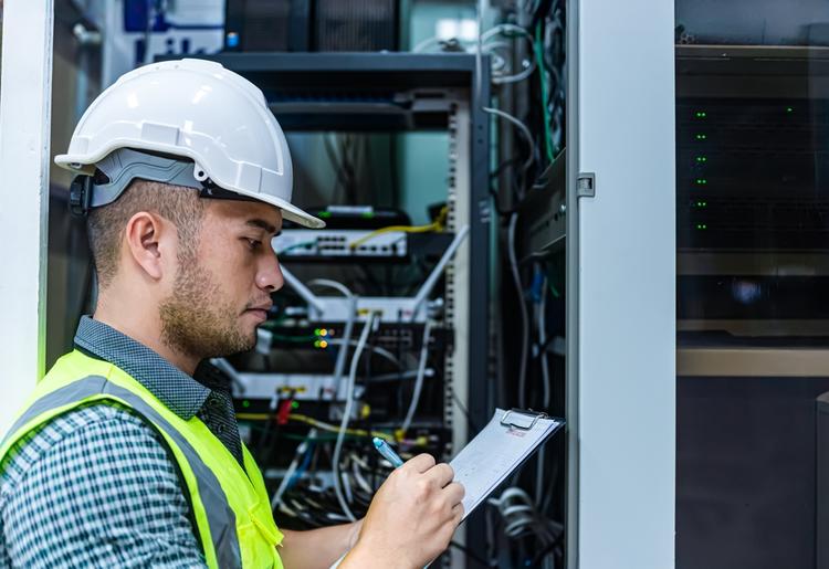 Field investigator reviewing work records in a telecommunications facility for Project Resource Group overtime settlement