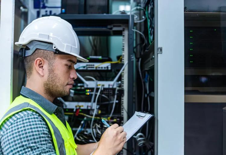 Field investigator reviewing work records in a telecommunications facility for Project Resource Group overtime settlement